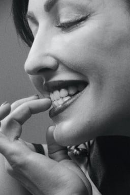 A woman chews on her fingernails, indicating the need for myofunctional therapy in Oak Park, IL