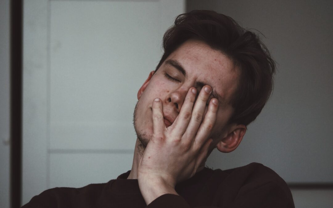 Man rests his head in his hand before root canal therapy