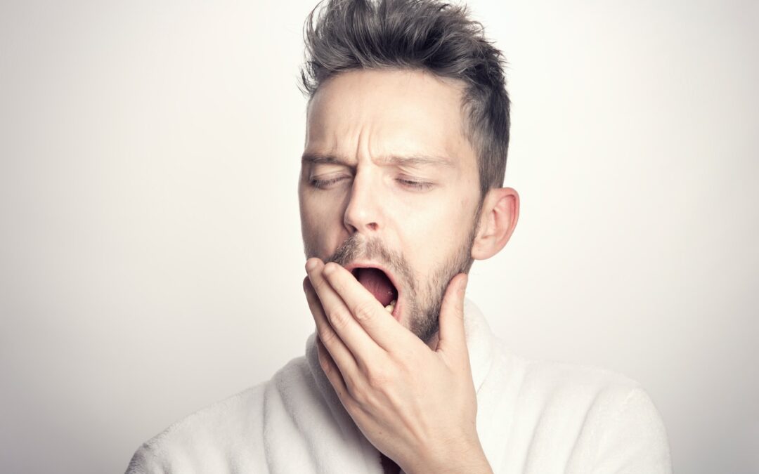 Man yawns and contemplates sleep apnea treatment