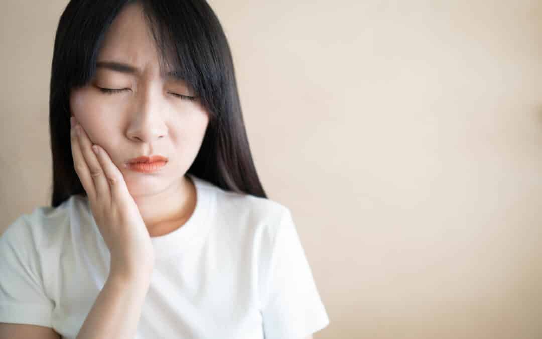 Young asian woman suffering from toothache or jaw pain. Cause of painful included tooth decay, inflammation, dental abscess, gum disease, sensitive teeth or trigeminal neuralgia. Health care concept.
