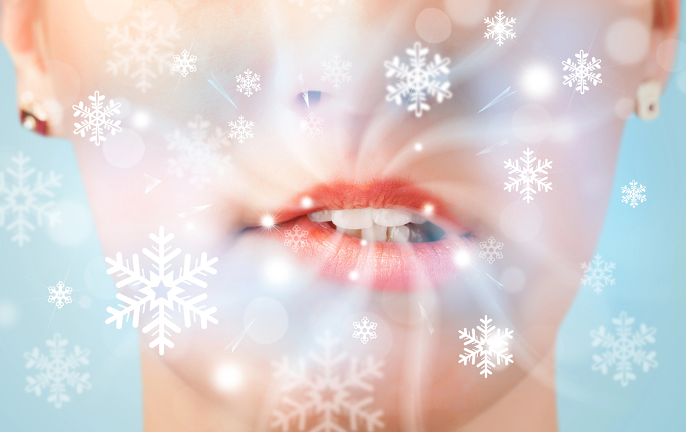 Pretty woman mouth blowing cold breeze